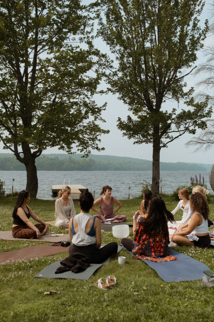 Women sitting in a circle on their yoga matts outside